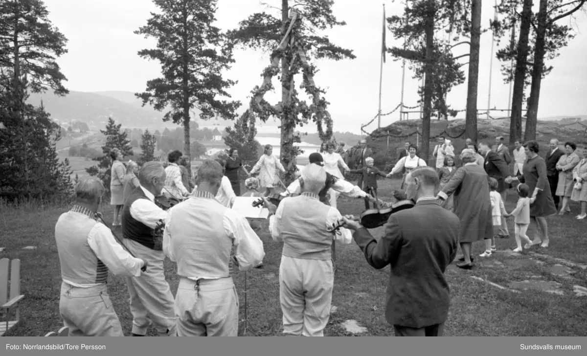 Midsommarfirande på Huberget i Stöde, med spelmän och dans kring midsommarstången.