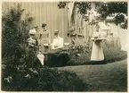 Från Berggrens trädgård på Kronogatan 7 i Vänersborg på 1890-talet. Kaffebrickan kommer. Josephine Berggren, Ellen Petreson (sittande), mellan dem Lilly Berggren.