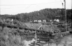 Nödinge. Surte. Surteraset 1950.

Jordskredet ägde rum kl. 08.11 den 29 september 1950, och varade i ca 3 minuter.
Över 30 hus drogs med i det 400 meter breda och 600 meter långa skredet av kvicklera ner mot Göta älv. Rasmassorna kom att blockera fartygstrafiken på älven i flera veckor.
En människa omkom i raset och ca 450 blev hemlösa.
Bara minuter innan raset hade ett persontåg med 800 passagerare passerat rasområdet. Både järnväg och stationshus sjönk ner i rasmassorna.