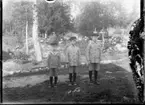 Erik, Hjärtum 1919-07-26, Nils, Hjärtum 1918-01-09, och Sven, Hjärtum 1915-05-14 finklädda för att börja skolan. På marken framför dem syns en liten hage med små hästar utskurna i trä.