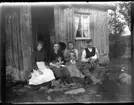 Rast på förstugutrappan, Torpängen juni 1915. Olga, född Olsson, Forshälla 1891-05-12, Okänd, Beda Jonsson född Björn, Bäve 1892-12-20, Abraham Jonsson, Hjärtum 1875-01-13. Abraham har en höna i famnen.