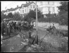 Begravningståg i Strömslund med bl a Strömslundsgatan 48 i bakgrunden och skylten bageri. Namnet otydligt - troligen Gustavssons bageri. Emil Gustavsson, Särestad 1877, hade bageri här från cirka 1907 till 1919.