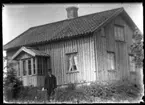 Anders Andersson, Forshälla 1888-10-13, stående framför det ännu omålade bostadshuset