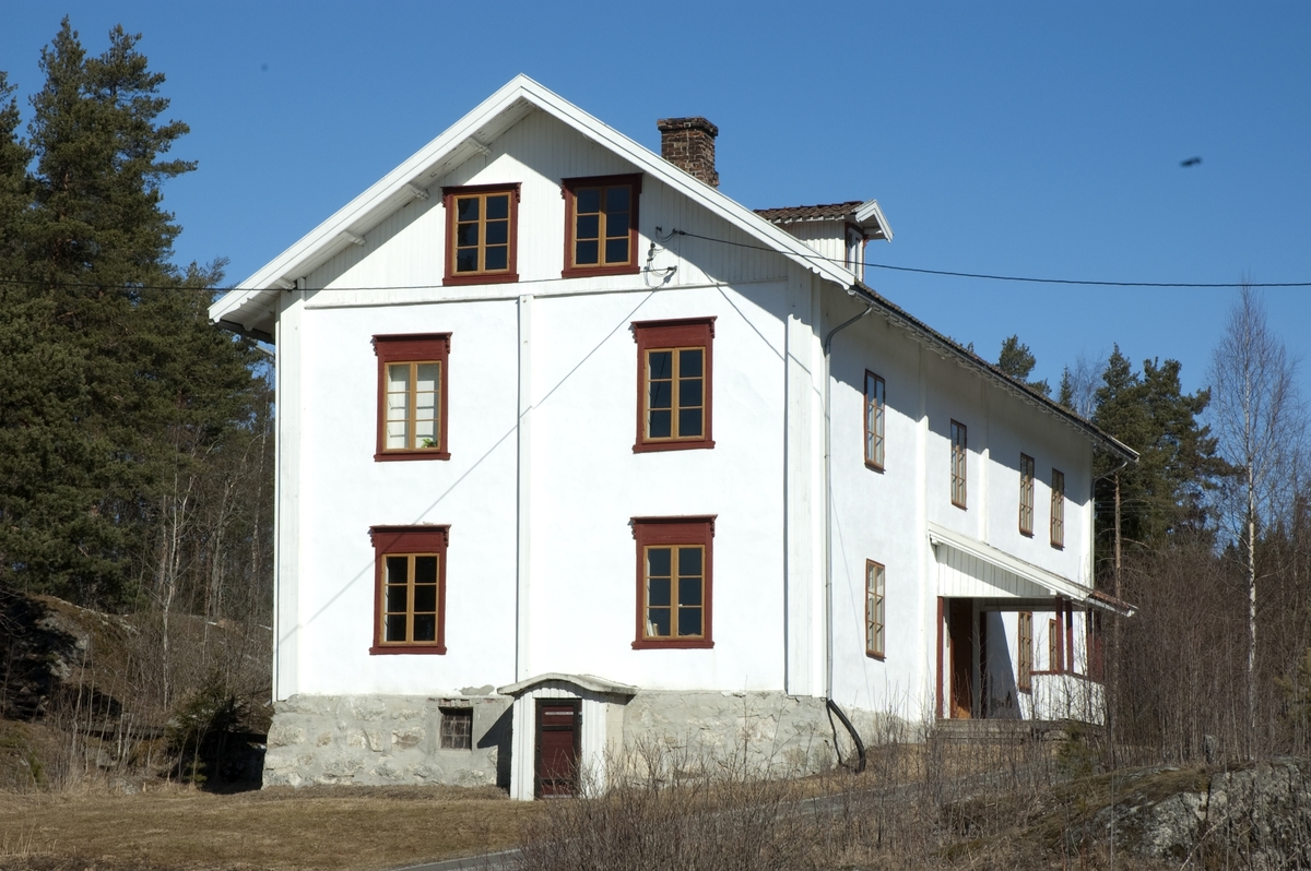 Klevfosboligen - oftest kalt bare kalt «Bolig’n» [med stum g] - er en 18, 9 meter lang og 8, 8 meter bred bygning, oppført av laftetømmer i to etasjer med rafthøyde på ….  meter.  Røstene er utført i bindingsverk med staffpanel som ytterkledning.  Bygningen kviler på en gråsteinmur, hovedsakelig murt av lokal granitt. I tillegg til å tjene som fundament for laftekonstruksjonene danner grunnmuren også yttervegger for to[?] store kjellerrom.  Sentralt på den «ytre» (søndre) delen av kjelleren, der muren rager 125-140 centimeter over bakken, er det oppsatt en kjellernedgang som er 150 centimeter bred og stikker 80 centimeter fram fra murlivet.  Her er sideveggene støpte, mens fronten er kledd med under- og overliggerpanel omkring ei labankdør, som ser ut til å være av nyere dato.  Oppå de støpte sideveggene i kjellernedgangen er det lagt et buet tak, som også er støpt.  Kjellermurkronas ytterkanter danner en 15-20 centimeter bred avsats langs de tømrete vegglivenes ytterkant, noe som sannsynligvis representerer en viss fare for oppsamling av fukt i forbindelse med slagregn- eller snø.  Klevfosboligens yttervegger er rappete, tilsynelatende med en sementliknende mørtel som antakelig har en noe annen konsistens enn den opprinnelige.  De rappete veggflatene er kvitmalte, og det er også laftekassene av bord, som stikker noe fram fra det øvrige vegglivet. Nederst, mot grunnmuren, har det løsnet noen flak av rappinga.  På østre langvegg ser man tydelig at ytterveggen er rydd, og at det er hogd hakk i tømmeret for å gi feste for den glattpussete flata med mørtel.  På gavlveggen i sør ser det ut til å være lagt et spileverk av lekter med samme formål.  Bolig’n har 27 vinduer.  Samtlige er såkalte empirevinduer med to fag, og med tre ruter i hver grind.  Vindusgrindene og midtstolpen er malt med en okergul farge, mens ramma rundt er rødmalt.  Det samme gjelder geriktene omkring vinduene, som det for øvrig bare er gavlen mot sør (mot vegen til Ådalsbruk) som har.  Denne fargen finner vi også igjen på den todelte inngangsdøra, som er plassert på langveggen mot øst.  Inngangen har to dørblad med speil, og i overkant er det et vindu med tre ruter, som slipper dagslys inn i en ellers vindusløs gang.  Døra er – med unntak av fasene på dørspeilene, som er røde – malt med den samme okergule fargen som vindusgrindene.  Foran inngangsdøra er det et repos – 3, 1meter bredt og 2, 2 meter dypt – med pulttak over.  Taket bæres av fire stolper som er reist på reposets ytterkant.  Disse, og innsida av den lave veggen som er montert mot stolperekka, er malt i den samme vinrøde fargen som er brukt på blant annet vinduskarmene.  Ellers er overbygget over inngangen til Klevfosboligen kvitmalt, både innvendig og utvendig.  Det later til at man siste gangen denne delen av bygningen ble påført kvitfarge brukte en malingstype med dårlige diffusjonsegenskaper, uten at dette har fått dramatiske konsekvenser i denne luftige konstruksjonen. Bygningens yttervegger under det nevnte taket, omkring inngangsdøra, er ikke rappet, men i stedet kledd med under- og overliggerpanel.  Underliggerne er brede bord, mens overliggerne er forholdsvis smale (drøyt 6 centimeter brede) og har staffprofiler langs kantflatene som vender ut.  På gavlveggen mot nordøst er det ei om lag 3, 4 meter bred veggflate, som verken er rappet eller bordkledd.  Her har det en gang vært et trappehus av bordkledd bindingsverk.  De gjenkabbete døråpningene som førte fra trappehuset inn i bygningskjernen er fortsatt godt synlige. Gavlveggen mot nord er for øvrig forsterket i vertikal retning med labanker.  En slik labank finnes også ved nordenden av vestre langvegg.  Klevfosboligen har saltak som bæres av 18 sperrepar med profilerte avslutninger på endestykkene som bærer taktustikkene.  I gavlendene finnes det ni åsutstikk med samme profilering.  Taket stikker godt ut i forhold til veggflatene, som av den grunn ser ut til å ha blitt spart for fuktskader.  Yttertaket er tekket med krumtegl av den gamle typen, som var så mye brukt på Hedmarken på 1800-tallet.  Sentralt på den øvre delen av den østre takflata er det ark med tofags funkisvinduer i fronten.  Sideveggene på arken er kledd med kvitmalt over- og underliggerpanel, der det er brukt smale lekter som overliggere. 

Går man inn døra i Bolig’n kommer man først inn i en gang som er 395 centimeter bred og 290 centimeter djup.  Herfra er det dører til rom både til venstre, rett fram og til høyre.  Dreier man til venstre finner man også trappa til 2. etasje.  Trappa er todelt.  Man går først fem trinn opp til et repos (100 X 96 centimeter),  Overflata på reposet befinner seg 110 centimeter over golvflata i 1. etasje.  Derfra fortsetter trappeløpet langs østre yttervegg, med ni trinn før man når golvet i 2. etasje.  Takhøyden i gangen i 1. etasje er på 280 centimeter.  Gangrommet har staffpanelte vegger, som er malt med lysegrønn farge.  Denne malinga er også brukt på to hjørneskap av høvlet glattpanel i den nordre delen av rommet, på yttersida av trappevangene, gelenderet og et lite skap under trappereposet.  Golvet og trappetrinnene er brunmalte.  Golvbordene umiddelbart innenfor ytterdøra bærer preg av at mange har tråkket på dem gjennom årenes løp.  Det samme gjelder den midtre delen av trappetrinnene.  Taket i gangen er i likhet med veggene kledd med staffpanel, som er kvitmalt.  

Går en døra til høyre kommer en inn i et rom som måler 410 centimeter i retning nord-sør og 415 centimeter i retning øst vest.  Rommet er kledd med faspanel på alle vegger og i taket.  På østveggen er det ett vindu, og i det nordvestre hjørnet ei teglsteinspipe med 115 centimeter lan brannmur mot vestveggen.  Fra brannmuren og sørøver denne veggen står det en kjøkkenbenk som kan se ut til å være fra 1930-40-åra.  Også i dette rommet er taket kvitmalt, veggene, brannmuren og pipa er guloransje, og golvet er grønnmalt.  Det består for øvrig av 7, 7 centimeter brede golvbord med not og fjær, en golvkledning som antakelig er lagt oppå et eldre golv. 

Fra det sist beskrevne rommet kan en fortsette vandringa til det nordøstre rommet i Bolig’n..  Grunnflata her måler 407 centimeter langt i retning nord-sør og 414 centimeter i retning øst-vest. Også her er vegger og tak kledd med staffpanel.  Taket er gulkvitt, veggene lyst gulgrønne.  Golvet er belagt med 13, 3 centimeter brede bord, som er brunmalte.  Golvet virker nytt, og er antakelig lagt etter at Bolig’n ble museumshus.  Det nordøstre rommet har to vinduer, ett på østveggen og ett på nordveggen.  I det sørvestre hjørnet av rommet er det pipe og brannmur, som er malt som veggene for øvrig. 

Ved siden av den nevnte brannmuren er det dør til det nordvestre rommet i Bolig’ns førsteetasje.  Det måler 410 centimeter i retning nord-sør og420 centimeter i retning øst-vest.  Også her er det staffpanel i taket og på veggene, og det er samme type golvbord som på forrige rom.  Taket er gulkvitt, veggene gråbrune og golvet brunt.  Rommet har ett vindu på vestveggen.  På nordveggen er en eldre, 106 centimeter bred døråpning til et tidligere trappehus på nordgavlen gjenkledd med staffpanel.  I det sørøstre hjørnet av rommet står en drøyt to meter høy etasjeovn fra Aadals Brug.  Da bygningen ble registrert var det røyset såpass mye tungt utstillingsmateriell rundt ovnen at det ikke lot seg gjøre å lese eventuell typebetegnelse. 
Går en så tilbake til gangen i første etasje og tar døra rett fram, kommer en inn i noe som nok både før og etter at Bolig’n kom til Klefos har vært et kjøkken.  Rommet måler 390 centimeter i retning nord-sør og 525 centimeter i retning øst-vest.  Taket og veggene er også her kledd med staffpanel, taket er kvitmalt, veggene, samt pipa og brannmuren i den sørøstre delen av rommet, er grårosa.  Golvet er også i dette rommet brunmalt.  Slitasjen tyder på at det er det golvet som ble lagt da bygningen ble gjenoppført på Klevfos i slutten av 1880-åra.  Rommet har to vinduer på vestveggen.  I den sørvestre delen av dette rommet står det et matskap, lagd av faspanel. 

Går en inn døra på nordveggen i det nettopp beskrevne rommet, kommer en nok en gang til et rom med staffpanel i taket og i veggene.  Taket er kvitmalt, veggene er lysegrønne, med unntak av brannmuren i det nordøstre hjørnet, som er kvit.  Også her er det et nytt golv med 13, 3 centimeter brede, brunmalte bord.  Dette rommet har to vinduer på vestveggen.  I tillegg til den døra en kommer inn via på sørveggen, er det en gjenkledd døråpning på nordveggen også.  En gang har det altså vært en forbindelse mellom dette rommet og det som ligger i det nordvestre hjørnet av Bolig’n.  Grunnflata i det beskrevne rommet er 412 centimeter i retning nord-sør og 413 i retning øst-vest. 

I det sørvestre hjørnet av første etasje i Bolig’n er det et rom som er 564 centimeter langt i retning nord-sør og 391 centimeter i retning øst-vest.  Også her er det staffpanel i taket og på veggene.  På østveggen er en tidligere døråpning gjenkledd med faspanel.  Taket er kvitmalt, veggene lysegrønne.  Unntaket er brannmuren i det nordøstre hjørnet, som er lysegrå.  Her står det en etasjeovn fra Aadals Brug (No 17).  Det opprinnelige golvet ser ut til å være bevart.  Det er også her brunmalt. Rommet har ett vindu på sørveggen og ett på vestveggen. 
I det sørøstre hjørnet av Bolig’n er det to rom.  Fra gangen kommer en først inn i et kjøkken, der golvflata måler 321 centimeter i retning nord-sør og 430 centimeter i retning øst-vest.  Taket og tre av veggene er kledd med staffpanel.  Den søndre veggen og en gjenkledd døråpning på vestveggen er kledd med faspanel.  Taket er kvitt, veggene lysegrønne, og det gamle golvet er brunmalt.  Rommet har ett vindu på østveggen.  I det nordvestre hjørnet av rommet, like ved inngangsdøra, står det en liten etasjeovn fra Aadals Brug (nr. 71), og mot den søndre delen av vestveggen en liten kjøkkenbenk, lagd av faspanel. I taket er det en gipsrosett med diameter på 65 centimeter.  Den ble sannsynligvis plassert der før det ble avdelt et lite kammers i det sørøstre hjørnet av bygningen. 

Det nevnte kammerset har inngang fra foregående rom.  Golvflata er 236 centimeter lang i retning nord-sør og 430 centimeter lang i retning øst-vest.  Taket og veggene – unntatt nordveggen (mot foregående rom, hver det er faspanel – er kledd med staffpanel.  Taket er malt lyst grått, veggene er lysegrønne og golvet er brunt, som ellers i huset.  Rommet har ett vindu på sørveggen. 

I 2. etasje er det en gang som er 390 centimeter lang i retning nord-sør og 290 centimeter bred i retning øst-vest.  Unntatt fra dette arealet er trappa opp fra første etasje, som legger beslag på 2, 57 X 110 centimeter i det sørøstre hjørnet av rommet, og ei innkledd loftstrapp (150 X 81 centimeter) i det nordvestre hjørnet.  Trappeløpet mot 1, etasje er beskyttet med et gelender.  Under loftstrappa er det et innkledd skap.  Takhøyden i gangen i 2. etasje – og vel i 2. etasje generelt – er cirka 270 centimeter.  Gangen har tak og vegger som er kledd med staffpanel.  Taket er malt i en lysegrå farge, veggene og trappegelenderet er lysegrønne og golvet og trappene er brune.  Gangrommet har vindu på østveggen.  

Planløsningen i 2. etasje er ellers om lag den samme som i 1.  Tar en døra rett fram når en kommer opp trappa (på gangens nordvegg), kommer en inn i et kjøkkenrom, som måler 416 centimeter i retning nord-sør og 415 centimeter i retning øst-vest.  Taket og veggene er kledd med staffpanel.  Taket er gråkvitt, veggene lyseblå, mens golvet er brunmalt.  Rommet har ett vindu på østveggen.  I rommets nordvestre hjørne står en liten Jøtul-vedovn.  I det sørøstre hjørnet finner vi en kjøkkenbenk (172 X 48 centimeters benkeplate) med overskap (130 X 30 centimeter).  Kjøkkenet er ellers forsøkt innredet slik familiekjøkkenene i Bolig’n var i 1950åra. 

Fra foregående rom er det dør på nordveggen til det nordøstre rommet i Bolig’ns 2. etasje.  Dette rommet har ei grunnflate på 406 centimeter i retning nord-sør og 416 centimeter i retning øst-vest.  Taket og veggene er kledd med staffpanel.  Taket er malt lysegrått, veggene er lysegule, og golvet har den brune fargen som går igjen i hele huset.  Rommet har to vinduer, ett på østveggen og ett på nordveggen.  I det sørvestre hjørnet står det en etasjeovn fra Aadals Brug (No 17).  Rommet er innredet som stue fra 1950-åra.  

På vestveggen i foregående rom er det dør til det nordvestre rommet i Bolig’ns 2. etasje.  Grunnflata er på 420 centimeter i retning nord-sør og 413 centimeter i retning øst-vest.  Taket og veggene er kledd med staffpanel.  Taket er gulgrått, veggene lysegrønne og golvet brunt.  Brannmuren i det sørøstre hjørnet er kvitmalt.  På nordveggen er en døråpning til et tidligere trappehus på nordgavlen gjenkledd.  Rommet har ett vindu på vestveggen.  På sørveggen er det dør til tilstøtende leilighet.  Rommet er innredet som familiesoverom fra 1950-åra. 

Går vi tilbake til gangen i 2. etasje og velger døra på vestveggen kommer vi inn i et kjøkkenrom som måler 392 centimeter i retning nord-sør og 528 centimeter i retning øst-vest.  I det sørøstre hjørnet er det ei stor pipe (89 X 79 centimeter) med en drøyt 120 centimeter lang brannmurforlengelse langs sørveggen.  Her står det en vedkomfyr (Aadals Brug No 125).  I det nordøstre hjørnet er det en kjøkkenbenk (175 X 58 centimeters plate) med hjørneskap over.  Rommet har vindu på vestveggen og dører til tilstøtende rom, både på nord- og sørveggen.  Kjøkkenet er forsøkt innredet slik informanter har fortalt at Klevfos-arbeiderfamiliens kjøkkener var i 1930-åra. 

Rommet sør for foregående rom har ei grunnflate på 575 centimeter i retning nord-sør og 390 centimeter i retning øst-vest.  Det har ett vindu på sørveggen og ett på vestveggen.  Både tak og vegger er kledd med staffpanel.  Taket er kvitmalt, veggene rosa og golvet brunt.  I det nordøstre hjørnet står en etasjeovn – Aadals Brug No 76.  Rommet er innredet som kombinert stue og soverom, noe som var vanlig i arbeidermiljøet på Klevfos i 1930-åra. 

Velger vi døra på sørveggen fra gangen i 2. etasje, kommer vi inn i et rom som er 318 centimeter langt i retning nord-sør og 437 centimeter i retning øst-vest.  Også her er det staffpanel i taket og på veggene.  Taket er gulkvitt, veggene lysegrønne og golvet brunt.  Rommet har ett vindu på østveggen. I det nordvestre hjørnet står en vedkomfyr – Aadals Brug No 23.  I det sørvestre hjørnet en liten veggfast kjøkkenbenk. (1747 X 47). 

På sørveggen i foregående rom er det dør til et lite hjørnerom, 245 centimeter langt i retning nord-sør og 435 centimeter i retning øst-vest.  Staffpanel i tak og på vegger.  Taket er gråkvitt, veggene lysegrønne og golvet brunt.  I nordvestre hjørne er det brannmur med plass for vedovn, som ikke er intakt. 

Sentralt i den søndre delen av loftet er det et 580 cm langt og 437 bredt rom, der tak og vegger er kledd med staffpanel.  Taket er kvitmalt og veggene lyseblå.  På østre og vestre side av rommet, der takhøyden er lav, er det kott uten vinduer.  I den nordre enden av loftet er det også innredet et boligrom.  Golvflata måler 423 centimeter i retning nord-sør og 440 centimeter i retning øst-vest. Også her er vegger og tak kledd med staffpanel, men til forskjell fra i alle andre rom i dette huset er veggkledningen lagt horisontalt. Taket er kvitmalt, veggene rosalilla.  Også her er det vinduløse kott mot husets langvegger (øst og vest) der takhøyden på loftet er lav.  Begge de panelte enderommene på loftet har to vinduer på gavlveggene.  Den midtre delen av loftet har aldri vært innredet til boligformål.  Her er det tre kott med enkle bordvegger på østsida og fire nisjer på vestsida av bygningen. 
