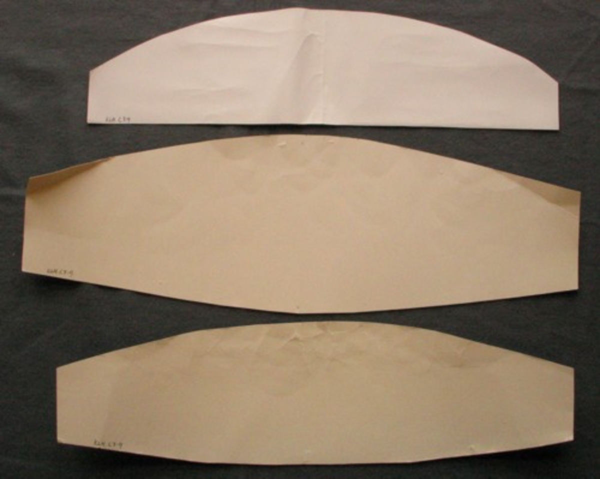 Stomme till kluten. Klutspån och tre olika jor för olika höjd på uppbindningen av kluten. Spånet  (ovalt 220 X 175 mm, höjd 30 mm) gjort av kartong som klätts med halvblekt linnetyg, lagda veck i kanten. Joren gjorda i kartong. Längd och höjd: 480 X114, 464 X130 och 517 X 168 mm.