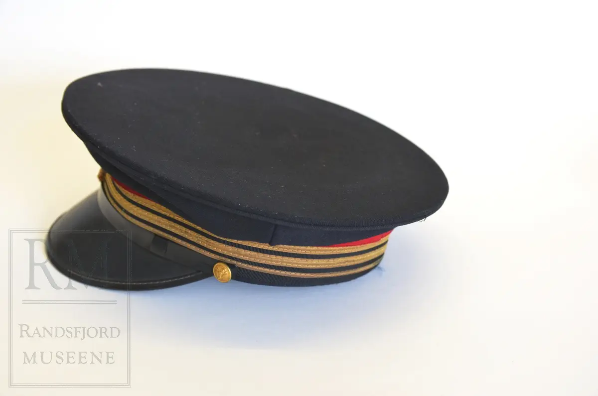 Jakke, bukse, slips, stasjonsmesterlue og skjorte.

a) Terylene, mørkeblå toskaftvevet. Fóret med svart kunstilke. Midtsøm i ryggen med splitt nederst, sidesømmer. Nedbrettet krage og slag. Enkeltspent med rette forkanter med 4 knapper med Norske løve i gult metall og knapphull. Utenpåsydde brystlommer med fold og knapping på klaff. Stikklommer med klaff. Tosømserme med 3 "Gull"-snorer. Rensemerke på innerlomme. Det er 3 innerlommer.

b) Langbukse med press uten oppbrett. Gylf med knapping. Linning med stolper til belte. 2 baklommer og 2 stikklommer. Nylon lomme- og linningsfór. 

c) Slips av blå kunstsilke. Knyttet. Fabrikkmerke "Derby Rhodia"

d): Skyggelue i svart ullstoff. Flat, rund pill. Plastskygge. Svetterem av brunt skinn. NSB emblem foran. Tre gullsnorer og rød snor i strikk. Rosett på gullsnor. Svart plastbånd festet med knapp på hver side. Fabrikkmerke.

e) Skjorte, lyseblå polyester og bomull fra Selje Skjortefabrikk. I plastpose. Ikke åpnet. Aldri brukt.