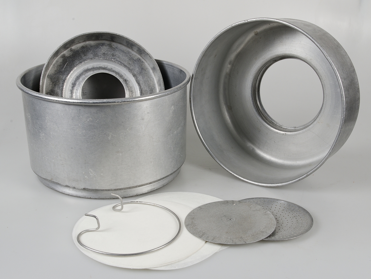 Apparat av aluminium för silning och kylning av mjölk. Hela apparaten består av sju delar:
1) ring för applicering på mjölkflaska.
2) kyldel, konisk, med dubbla väggar, avtappningskran av mässing, tillflödesskiva, gummislang.
3) mellankärl med små hål för att få mjölken att rinna längs väggarna i del 2
4) mjölksil med stort hål för att få mjölken att rinna längs väggarna i del 2
5) silplatta med många fina hål
6) silplatta med grövre och färre hål
7) ring för fasthållande av filter och sil, ett antal pappersfilter medföljer.