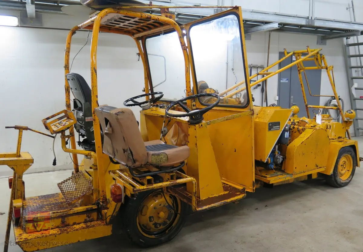 To-akslet hjulgående maskin med delvis åpen førerplass. Maskina har en 4-sylindret bensindrevet Volkswagen 1600 ccm motor av typen 126A med en effekt på 36 din hk ved 2600 omdreininger. Motornummer er 126.055909. Motoren er krafkilde både for fremdrift og sprøytekompressor. Fremdriften er trinnløs hydrostatisk (hydraulisk). Girkassen er en Getrag BY Nr. 27709. Kompressoren er av fabrikat Ingersoll Rand, type 3, modell 71T som gir 1700 liter luft i minuttet. Tre sprøytepistoler av typen 10-40. To malingsbeholdere som hver rommer 200 liter. Maskinen betjenes av to personer. Maskinen har utstyr for kantmerking og midtmerking og maskina har styring på bakhjulene og drift på framhulene. Maskinen har to trafikkskilt påskrudd på taket.
