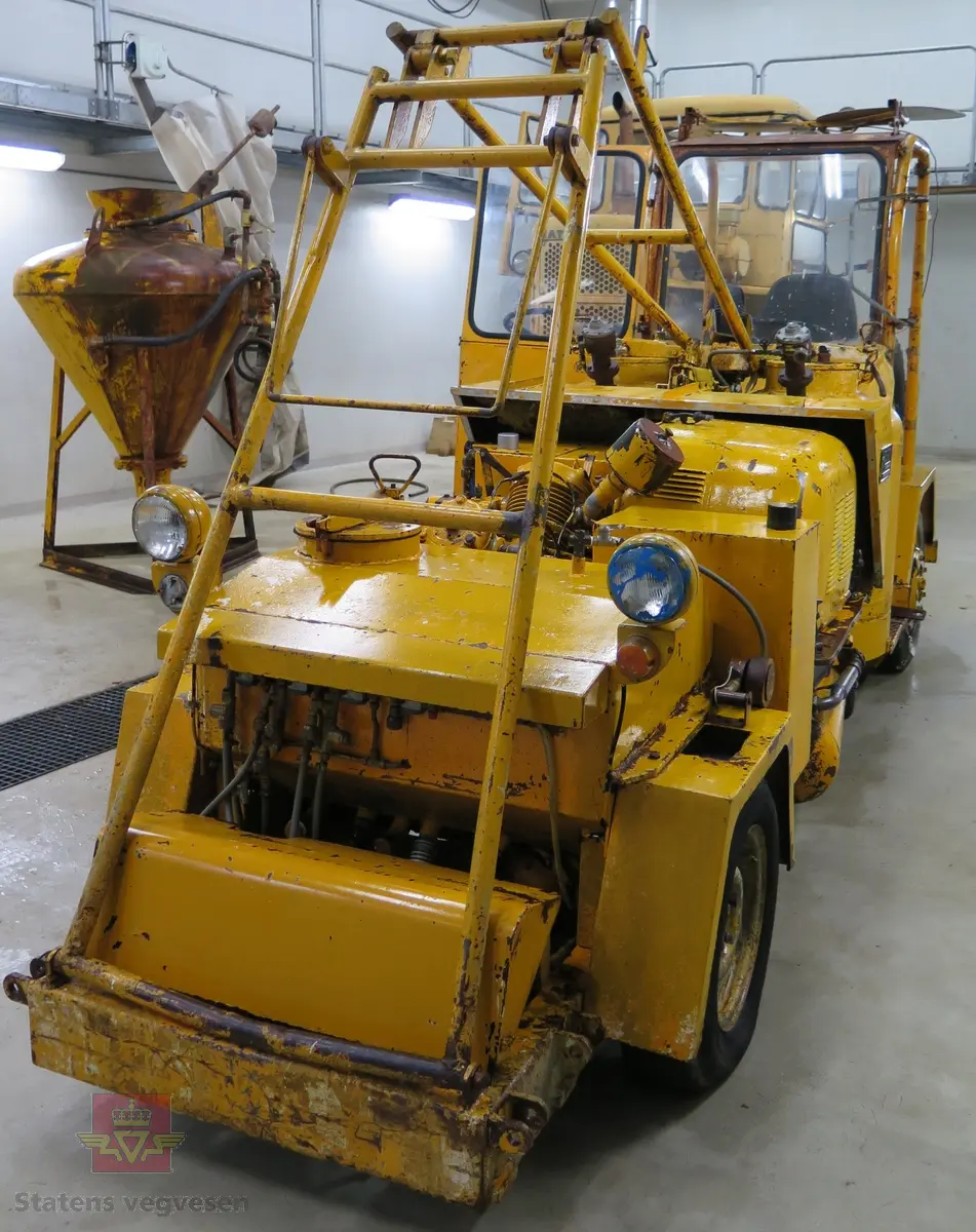 To-akslet hjulgående maskin med delvis åpen førerplass. Maskina har en 4-sylindret bensindrevet Volkswagen 1600 ccm motor av typen 126A med en effekt på 36 din hk ved 2600 omdreininger. Motornummer er 126.055909. Motoren er krafkilde både for fremdrift og sprøytekompressor. Fremdriften er trinnløs hydrostatisk (hydraulisk). Girkassen er en Getrag BY Nr. 27709. Kompressoren er av fabrikat Ingersoll Rand, type 3, modell 71T som gir 1700 liter luft i minuttet. Tre sprøytepistoler av typen 10-40. To malingsbeholdere som hver rommer 200 liter. Maskinen betjenes av to personer. Maskinen har utstyr for kantmerking og midtmerking og maskina har styring på bakhjulene og drift på framhulene. Maskinen har to trafikkskilt påskrudd på taket.