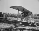 Flygplan Macchi M.7 märkt nummer 945 vid en brygga vid sjön Roxen vid Bergs slussar. Flygmekaniker i arbete med propellern.