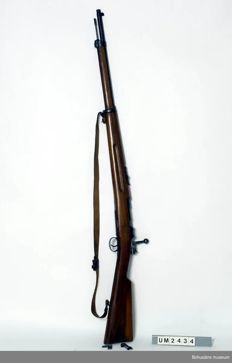 Kulgevär C-G 6,5 x 55.

Ur handskrivna katalogen 1957-1958:
Armégevär, mauser
L. 126 cm, i gott skick; 1900; på manteln "O.G 54600". Remmen b) av läder. Läskstång c) L. 69,8 cm.