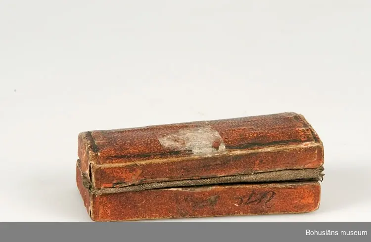 Ur handskrivna katalogen 1957-1958:
Snäppa
Snäppan a) L. 5,8 cm; mässing m. mekanismer av järn. Fodralet b) 7,2 x 3,7 x ,1 cm; trä, papper på utsid., tyg på insid. Trasigt.

Lappkatalog: 94