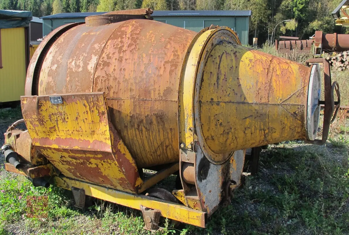 Skinnegående roterende betongtrommel med sporvidde 60 centimeter. Akselavstand er 100 centimeter. Gul og rød farge samt brunfarge grunnet rust. Utstyret har merking fra produsent.