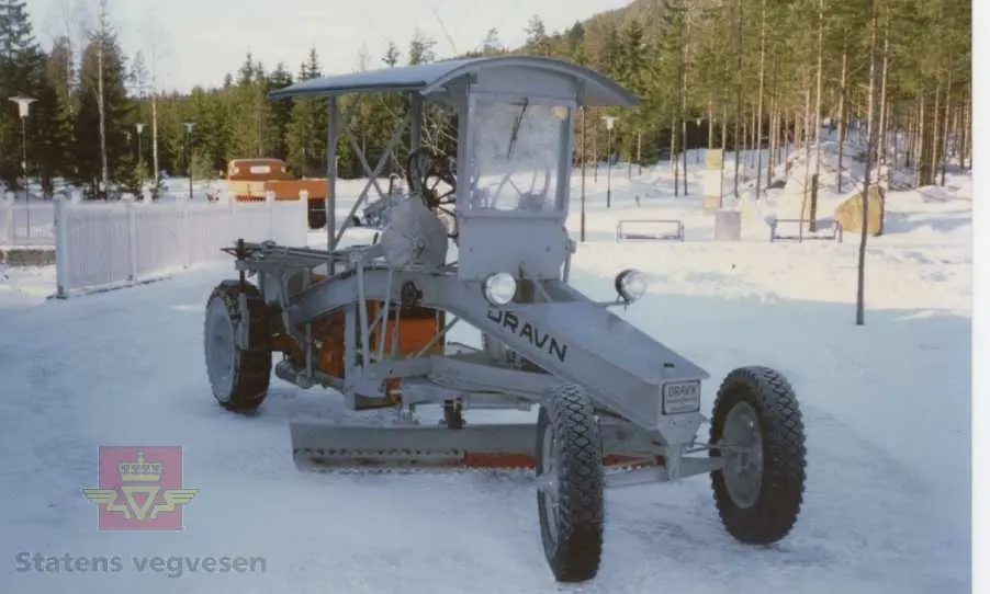 Veghøvel bygd på basisen av en Fordson traktor. Grå veghøvel med buet ramme og 4 hjul, (toakslet). Drift på bakhjulene. Dekk av kompakt gummi. Tak av tre. Sete for fører. Ratt for justering av skjær. Merking fra produsent. Motoren er en vannavkjølt 4-sylindret bensinmotor av typen Fordson som yter 30 Hk. Motoren kan også gå på parafin, da yter den 24 Hk. Motorfargen er oransje.
Høvelen er pusset opp til bra utvendig stand.