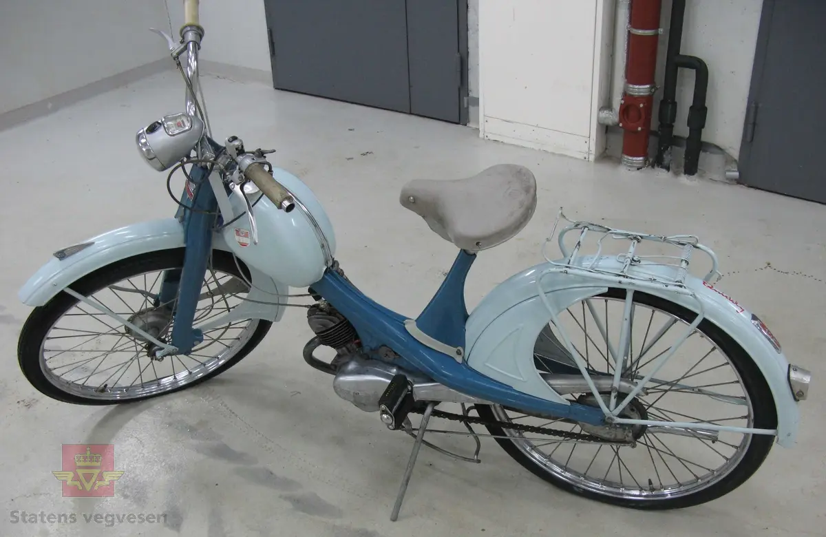 NSU Quickly. 2-hjuls moped med pedaler, (for å bidra til fremdrift). To farget blå med grått sete og styreholker. Merking i rødt og blått. Lykt foran og refleks bak. Merking på motoren viser at motortypen heter 51 ZT, med størrelse 49 ccm. Motornummer er 459127. Sylinderen i motoren er trolig mindre enn det merkeplata tilsier, (se historikk). 
Tidsriktig kåpe og sylinder med størrelse 49 ccm følger med mopeden. (disse gjenstandene har aldri vært brukt på akkurat denne mopeden, men på tilsvarende mopeder).