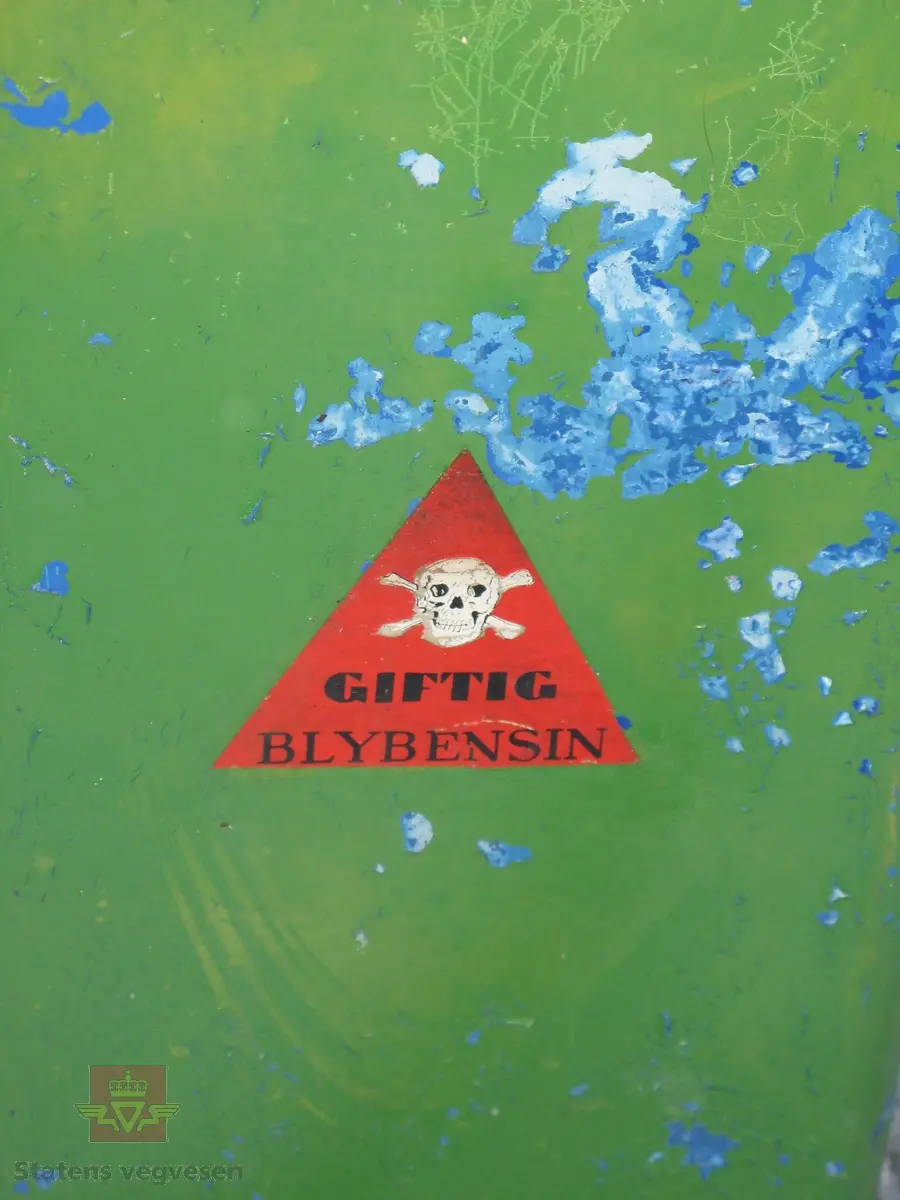 Flerfarget, hovedfarger er grønn og gul, (opprinnelig blå). Håndpumpe og porsjoneringsglass. Står på sokkel. Merking.
Trekasse med lokk høre til pumpa.