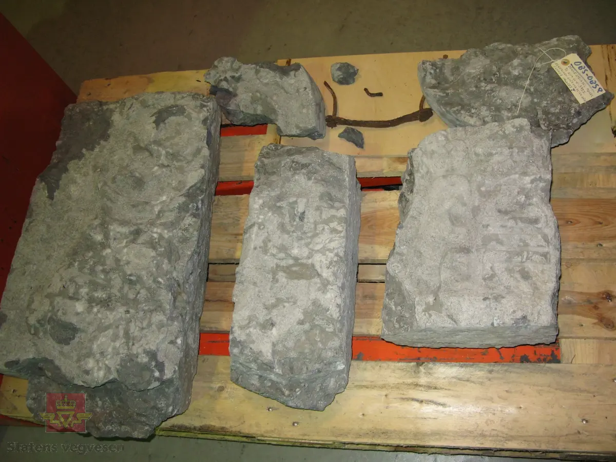 Grå kalkstein i 5 deler. Noe av monogrammet er borte, men 1687 er godt synelig. Kun den største delen er merket. Steinen er lagret på to paller.