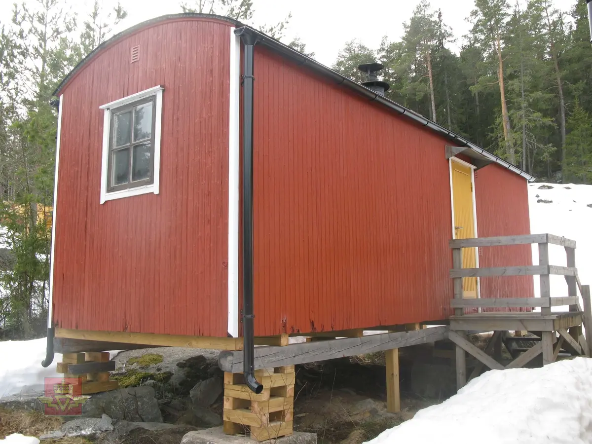 Rød hvilebrakke i tre, med et vindu i hver gavelvegg, ei dør i den ene langveggen og et vindu i den andre langveggen. Dør i gult og vinduskarmer i hvitt og brunt. Stående panel, hjørner har metallbeslag, (i hvitt). Takrenner i stål, (av nyere dato, montert ved NVM). Buet tak kledd med papp. Pipe med hatt. Skjerm over døra. Stigtrinnet ligger inne i brakka. To reflekser på den ene kortveggen. Brakka er innredet med bord, stoler, senger, madrasser, puter, diverse skap og en vedovn av typen Jøtul 380. Blå skap og brunmalt gulv, ellers oljet/lakkert innredning. Hvitt takk innvendig.
