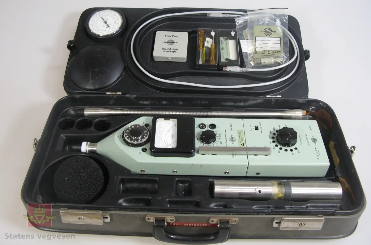 Rektangulært måleinstrument som måler støy, (desibel).
Ligger i koffert sammen med tilhørende deler. En skriver i egen veske samt stativ følger med.