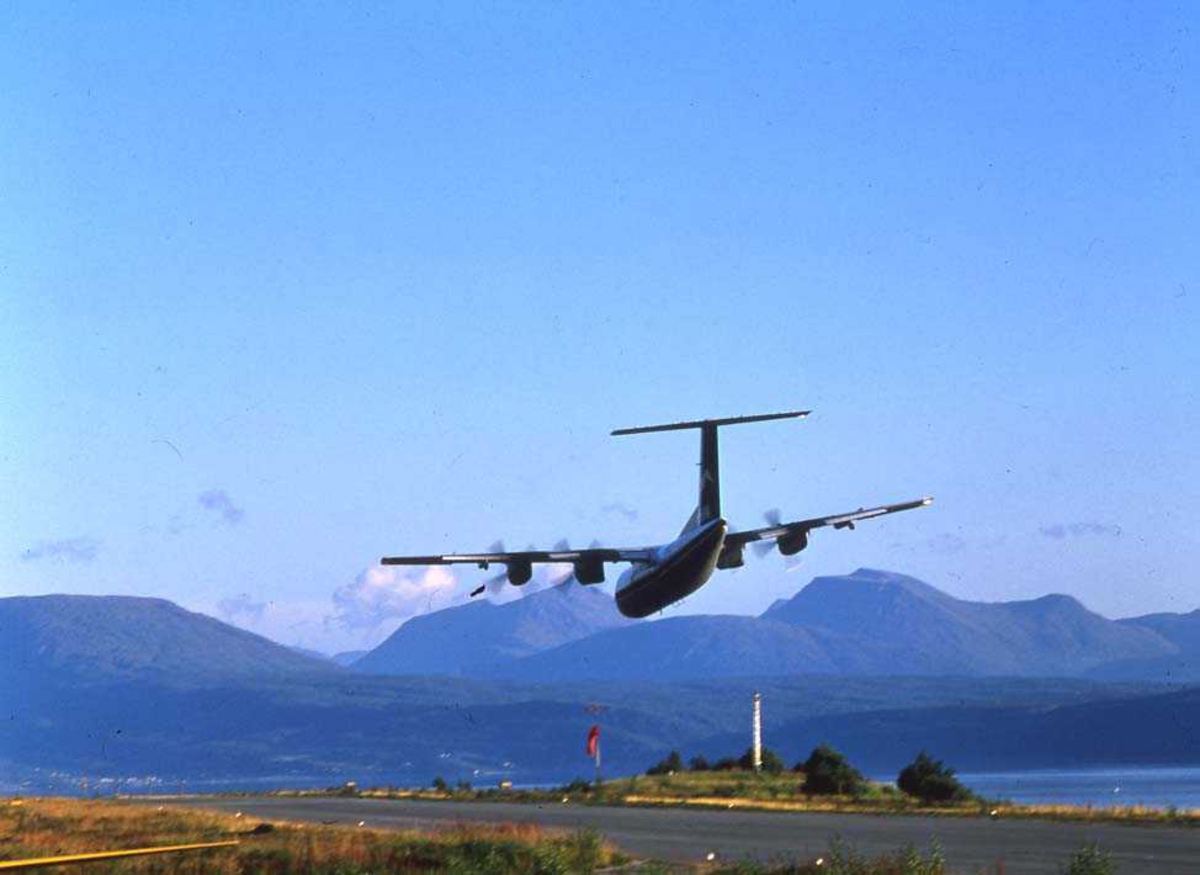 Lufthavn/flyplass. Narvik. Ett fly, DHC-7-102/ Dash 7 fra Widerøe,  foretar "low pass" over flyplassen.