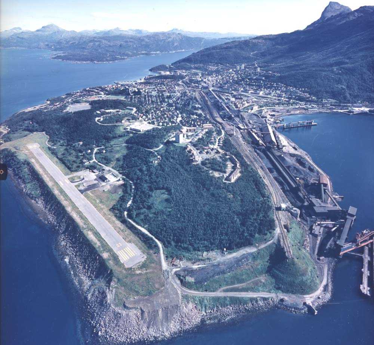 Lufthavn/Flyplass. ENNK-NVK. Narvik. Oversiktsbilde over flyplassen, topografien rundt og byen i bakgrunnen.
Baneretning/RWY 01/19.