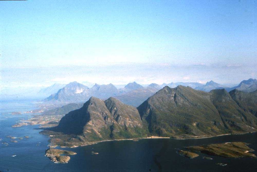 Luftfoto. Kjerringøy med fjell i Steigen i bakgrunn.
I forgrunn fjorden Mistfjorden og fjellet Fjærkjerringa.