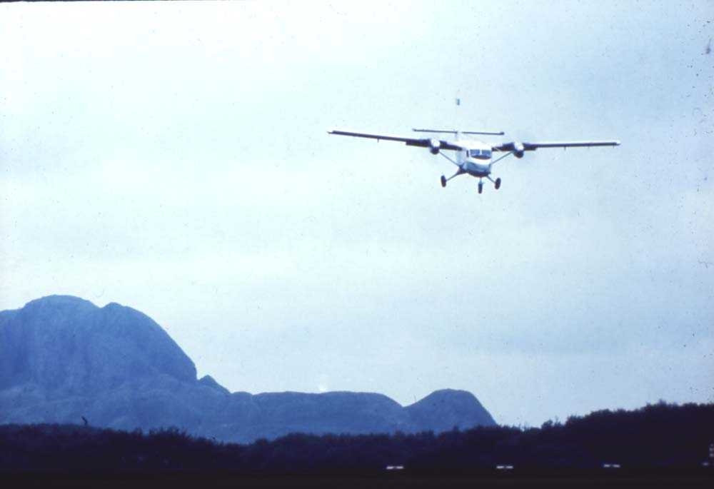 Lufthavn/flyplass. Brønnøysund. Et fly, DHC-6-300 Twin Otter fra Widerøe under innflyging runway 04. Parti fra Torghatten i bakgrunn.