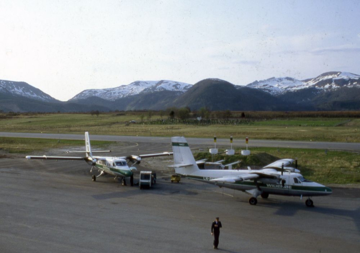 Lufthavn (flyplass). To fly, LN-BNM og LN-BNS, DHC-6-300 Twin Otter fra Widerøe parkert. En person (pilot)