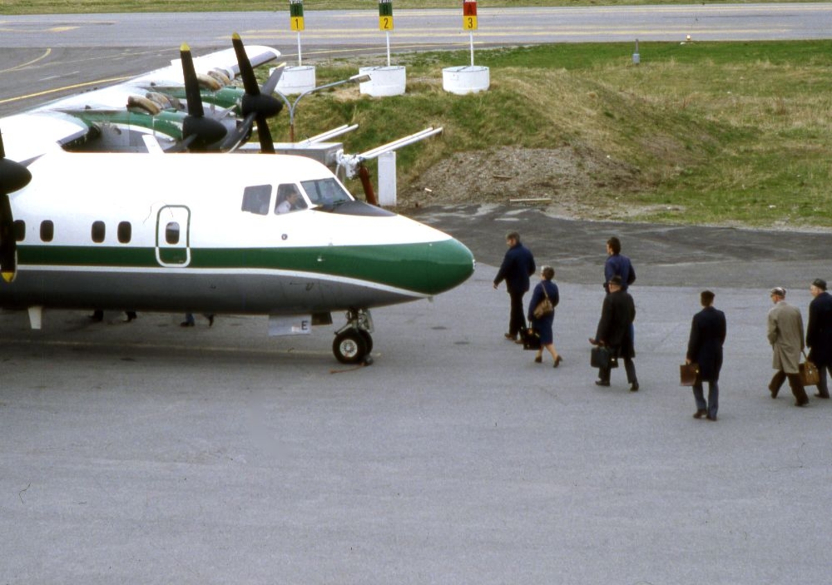 Lufthavn (flyplass). Et fly, LN-WFE, DHC-7-102, Dash7 fra Widerøe.
Flere passasjerer går ombord.