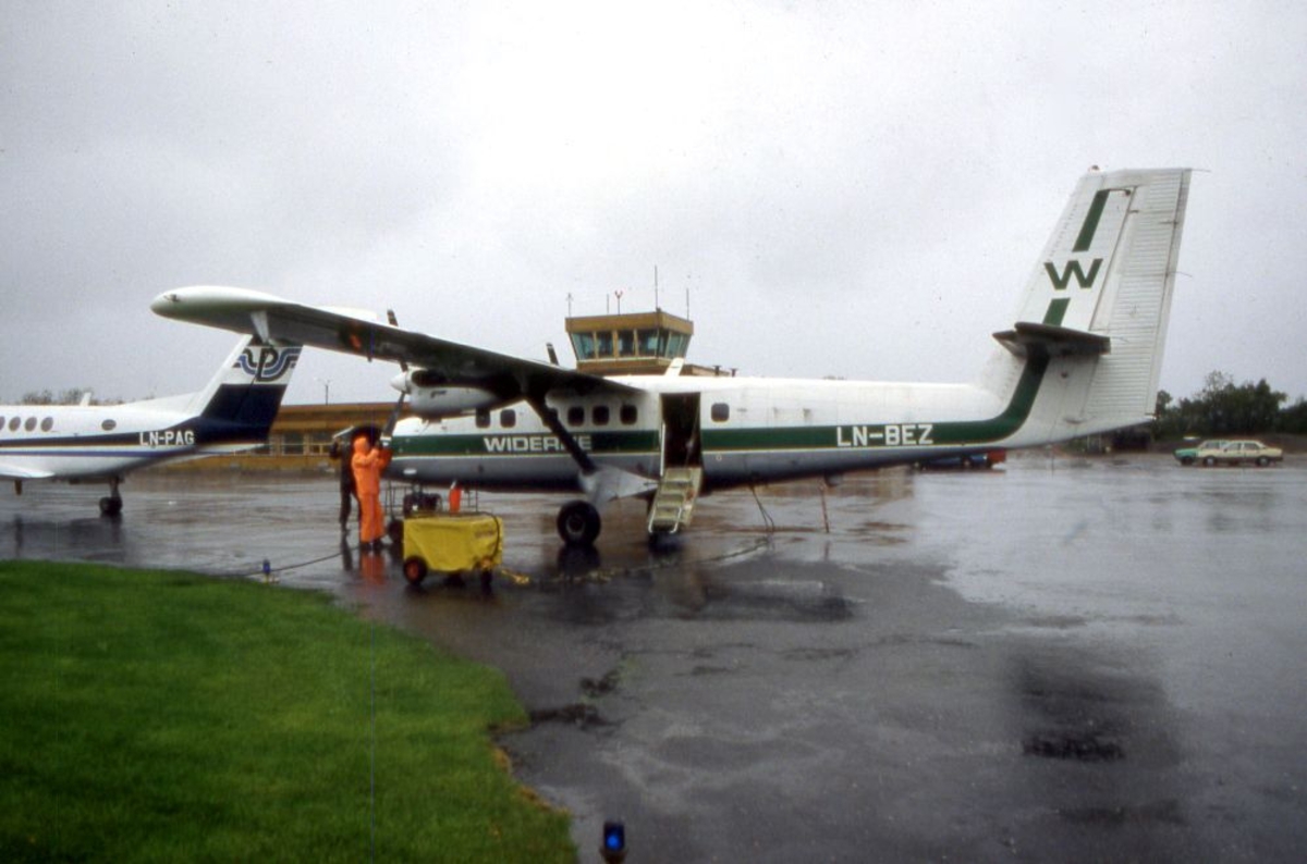 Lufthavn (flyplass). To fly, LN-BEZ, DHC-6-300 Twin Otter fra Widerøe og halepartiet på LN-PAG, Beech Super King Air fra Partnair. To personer på oppstillingsplassen (tarmac).