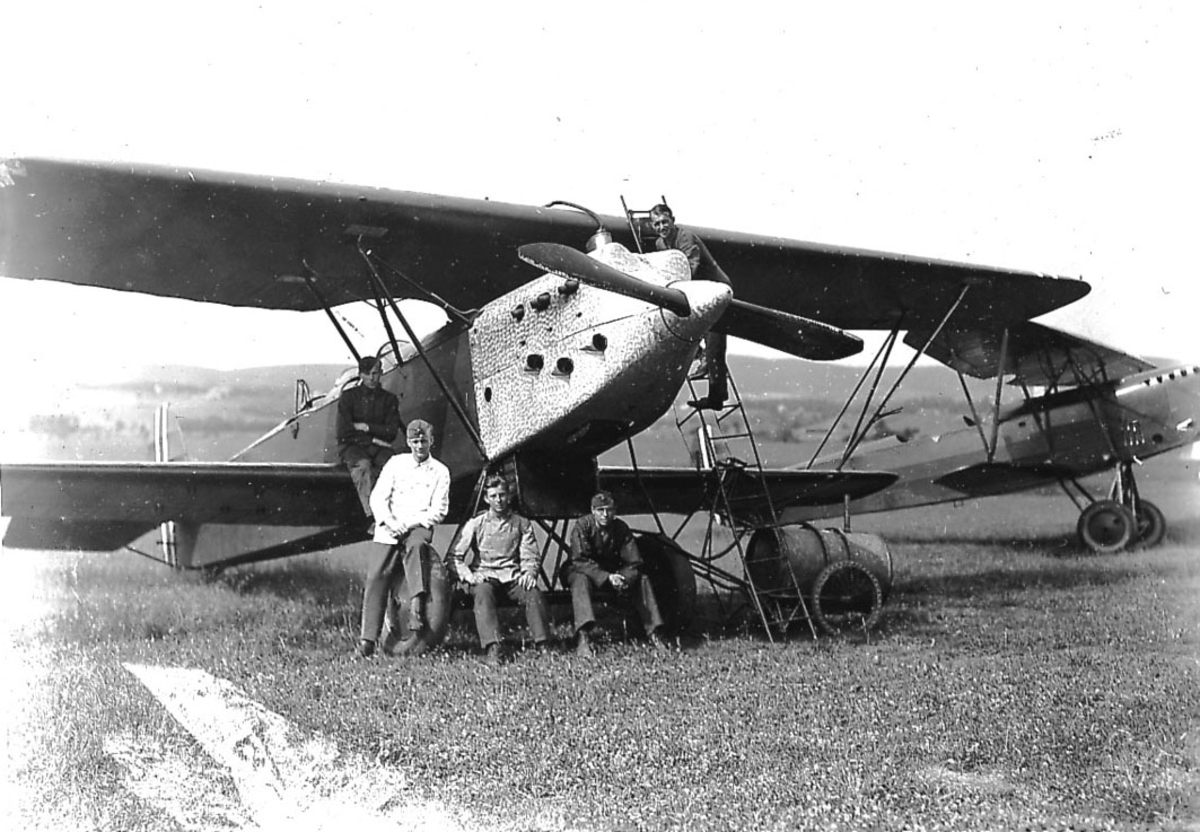 Kjeller lufthavn Gruppe fire personer foran ett fly, Fokker CVE. Ett annet fly bak.