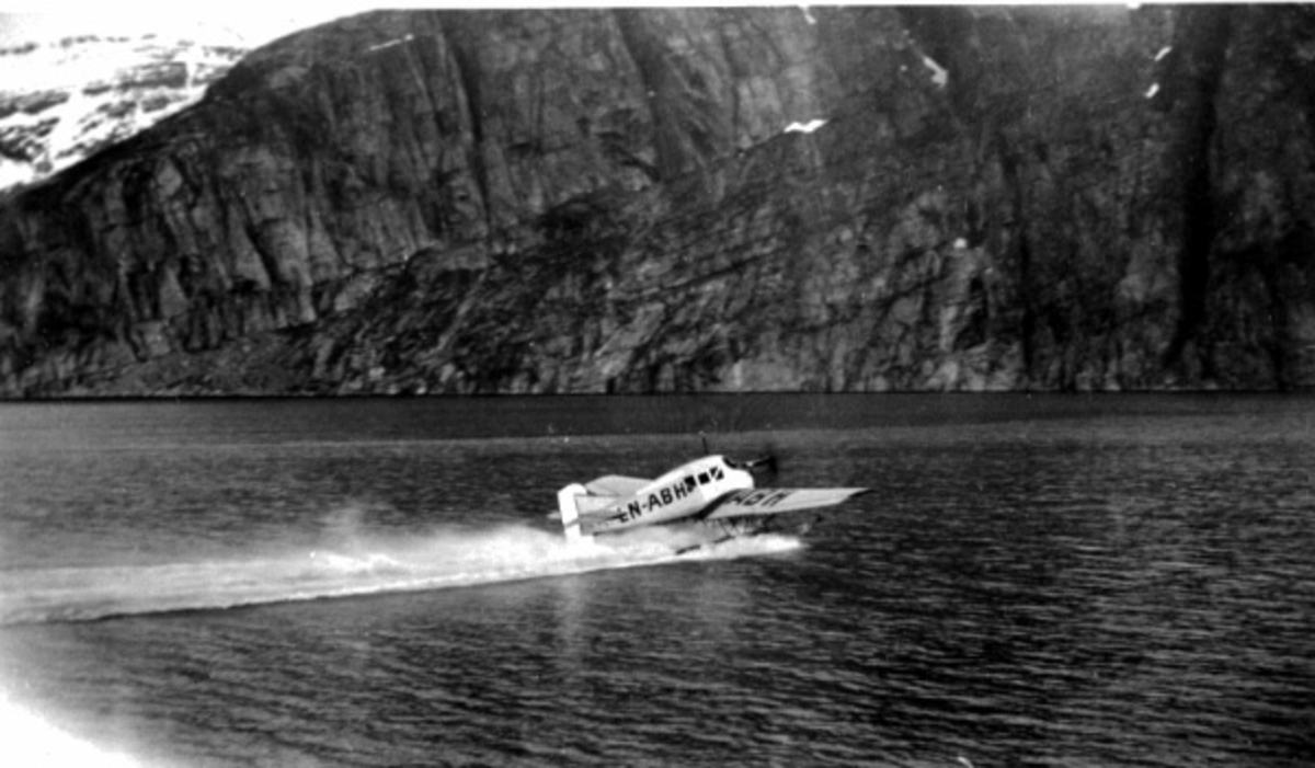 Fly i fart på havoverflata. Junkers F13W, LN-ABH. Fra siden. Fjell i bakgrunnen