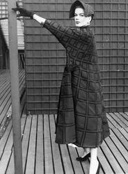 Modell klädd i rutig Fabiani- kappa, hatt, handskar och pump