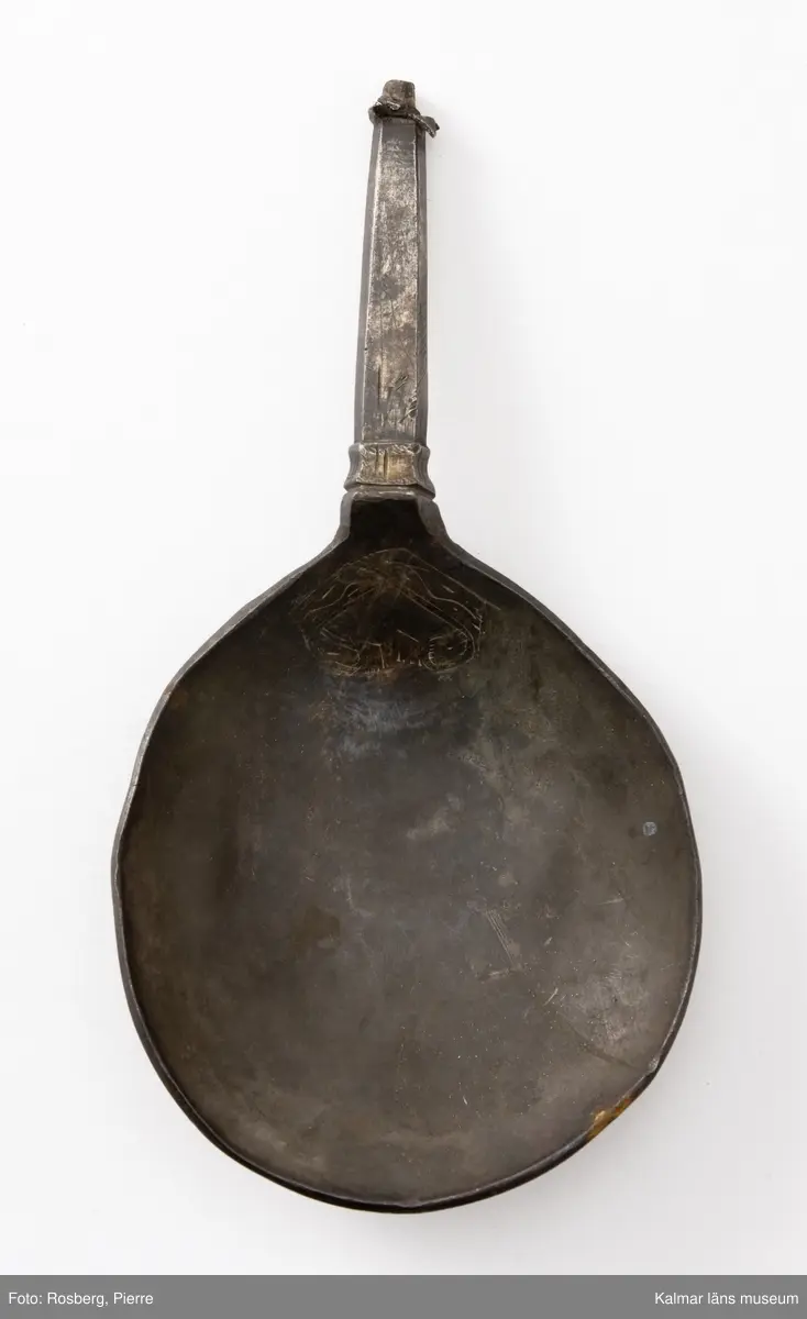 KLM 34757 Sked av metall, silver. Brett ovalt blad med sexkantigt skaft, skaftets avslutning är avbruten. I skedbladet banddekor. Rester av förgyllning, otydlig stämpel. Datering: 1500-tal?