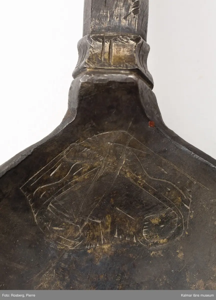 KLM 34757 Sked av metall, silver. Brett ovalt blad med sexkantigt skaft, skaftets avslutning är avbruten. I skedbladet banddekor. Rester av förgyllning, otydlig stämpel. Datering: 1500-tal?