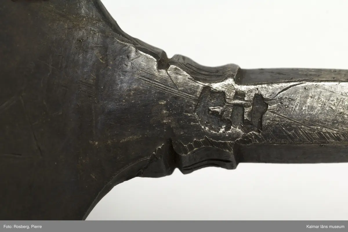 KLM 34757 Sked av metall, silver. Brett ovalt blad med sexkantigt skaft, skaftets avslutning är avbruten. I skedbladet banddekor. Rester av förgyllning, otydlig stämpel. Datering: 1500-tal?