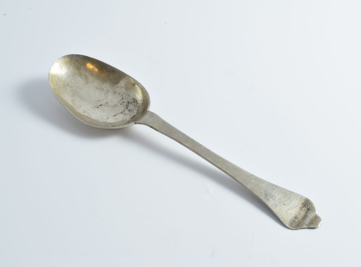 To sølvskjeer med gravert bladornament på baksiden av bladet.