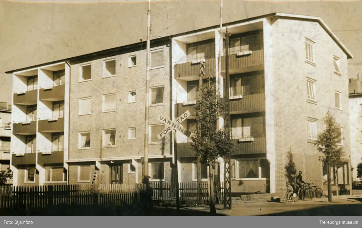 Bostadshus på Nygatan 29 i Trelleborg. I förgrunden järnvägsövergång med skylt som varnar för tåg. Järnvägen gick mellan Trelleborg Övre och Trelleborg Centralstation.