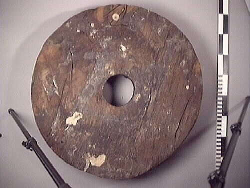 Lavetthjul fram, svåra skador och förorenad yta. Har avfasade kanter.

Front truck of a gun carriage, heavy damage and multiple impurities. Both bevelled edges.