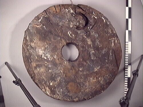 Lavetthjul fram, svåra skador och förorenad yta. Har avfasade kanter.

Front truck of a gun carriage, heavy damage and multiple impurities. Both bevelled edges.