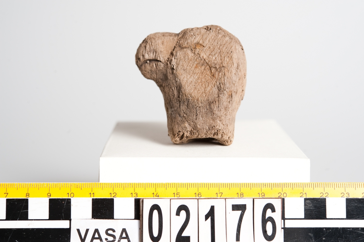 Litet, skulpterat fågelhuvud, troligtvis papegoja. Fågeln har en böjd näbb samt ett smalt öga. På undersidan av huvudet finns ett runt hål/urtag.
Skulpturen är mycket ömtålig, med småsprickor. Den ena sidan av fågelhuvudet är mycket nött och något tillplattat.