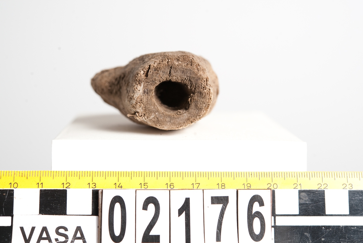 Litet, skulpterat fågelhuvud, troligtvis papegoja. Fågeln har en böjd näbb samt ett smalt öga. På undersidan av huvudet finns ett runt hål/urtag.
Skulpturen är mycket ömtålig, med småsprickor. Den ena sidan av fågelhuvudet är mycket nött och något tillplattat.
