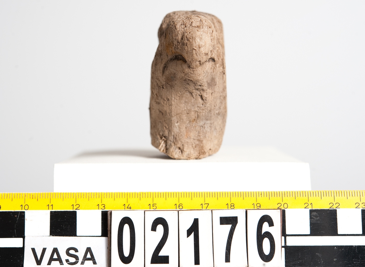 Litet, skulpterat fågelhuvud, troligtvis papegoja. Fågeln har en böjd näbb samt ett smalt öga. På undersidan av huvudet finns ett runt hål/urtag.
Skulpturen är mycket ömtålig, med småsprickor. Den ena sidan av fågelhuvudet är mycket nött och något tillplattat.