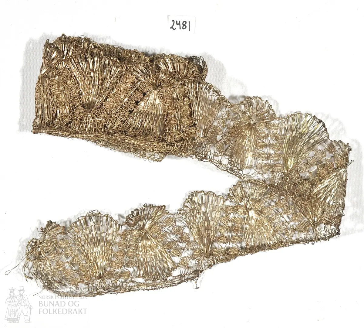Kniplingband av sølv.  
6 cm x ca 120 cm