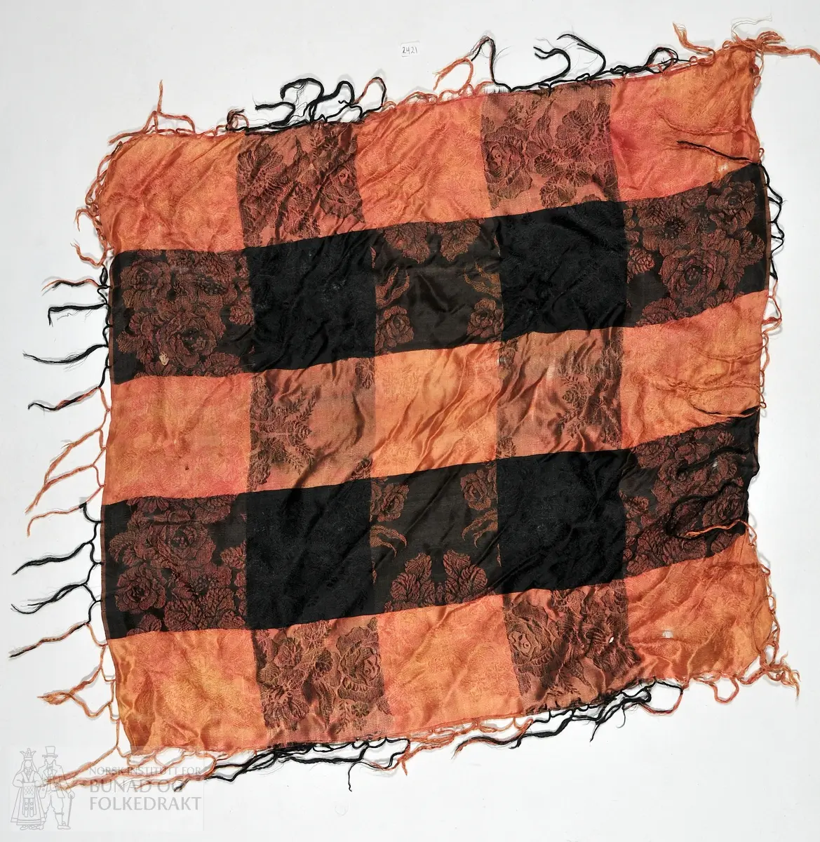 Silketørkle i lakserosa og svart med frynser. 
60x60cm