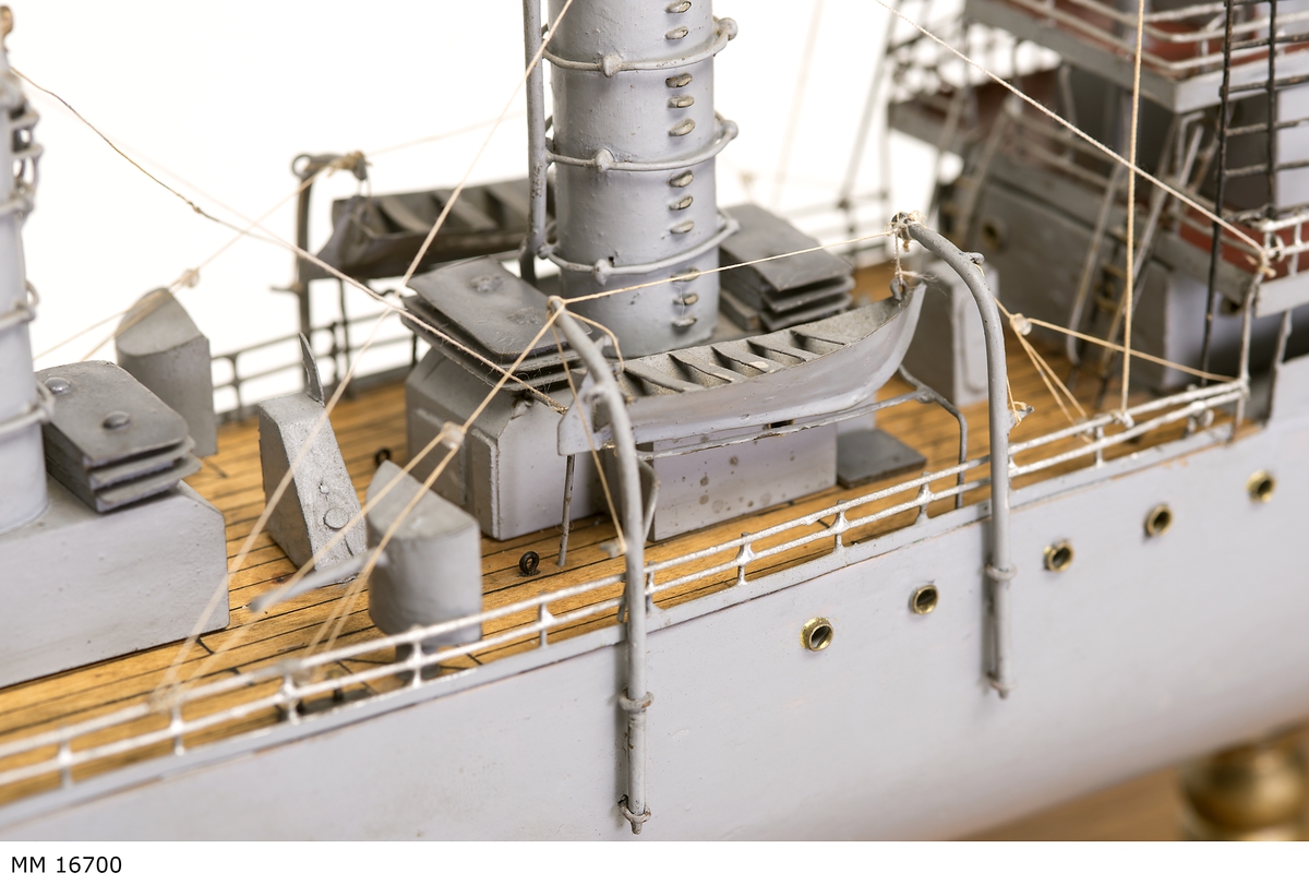 Gråmålad modell av tyska örlogsfartyget Albatross, monterad på ekplatta, samt därutöver glasmonter. På montern nysilverplatta graverad: "Till vännen Ivar Uggla av sina albatrossvänner Julen 1918".