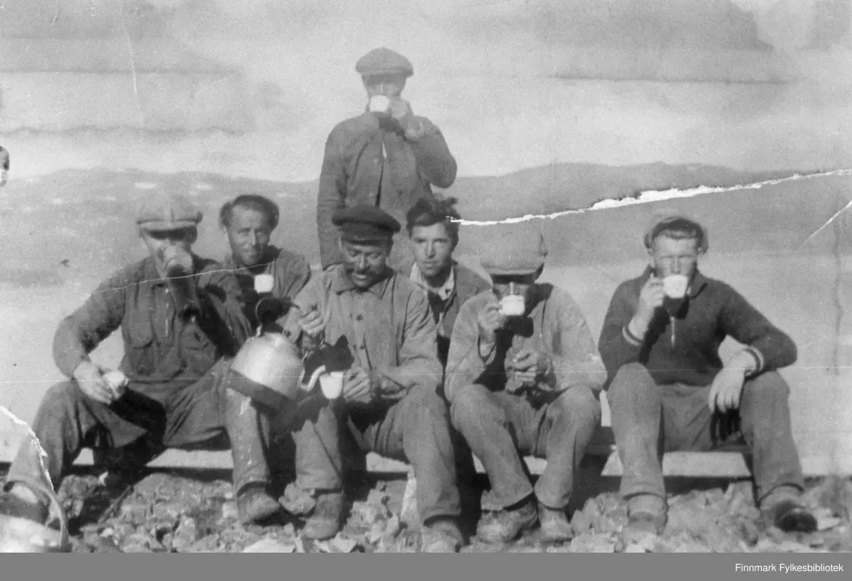 Veiarbeidere har tatt kaffepause i Langfjordbotn (Talvik) i 1937. Fra venstre: Birger Furu, Sigurd Digre, Georg Monsen, Trygve Rapp, Trygve Iversen, Hilmar Elverum og Aksel Iversen står helt bakerst.