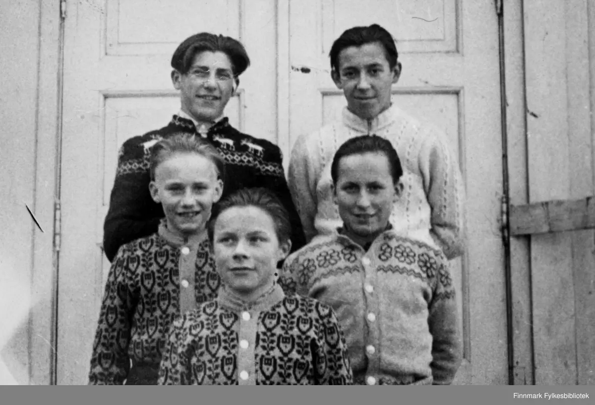 "Brylkremgutta" stiller til fotografering utenfor skoleinternatet på Skjånes, ved inngangen til gymnastikksalen. Der fantes også et lite kontor under galleriet, som ble brukt som tannlegekontor. En trapp førte opp til klokketårnet. Skolen var nemlig en gang bygget som skolekapell. Bildet kan være tatt i tidsperioden 1950-51.  Oppe fra venstre: Bjørn Nikolaisen, Arnold Nilsen, Ragnar Persen, Emil Corneliussen, Odin Bavda
