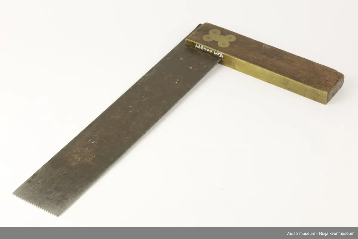 Vinkelhake av metall og tre. Måledelen av metall er merket i tommer.