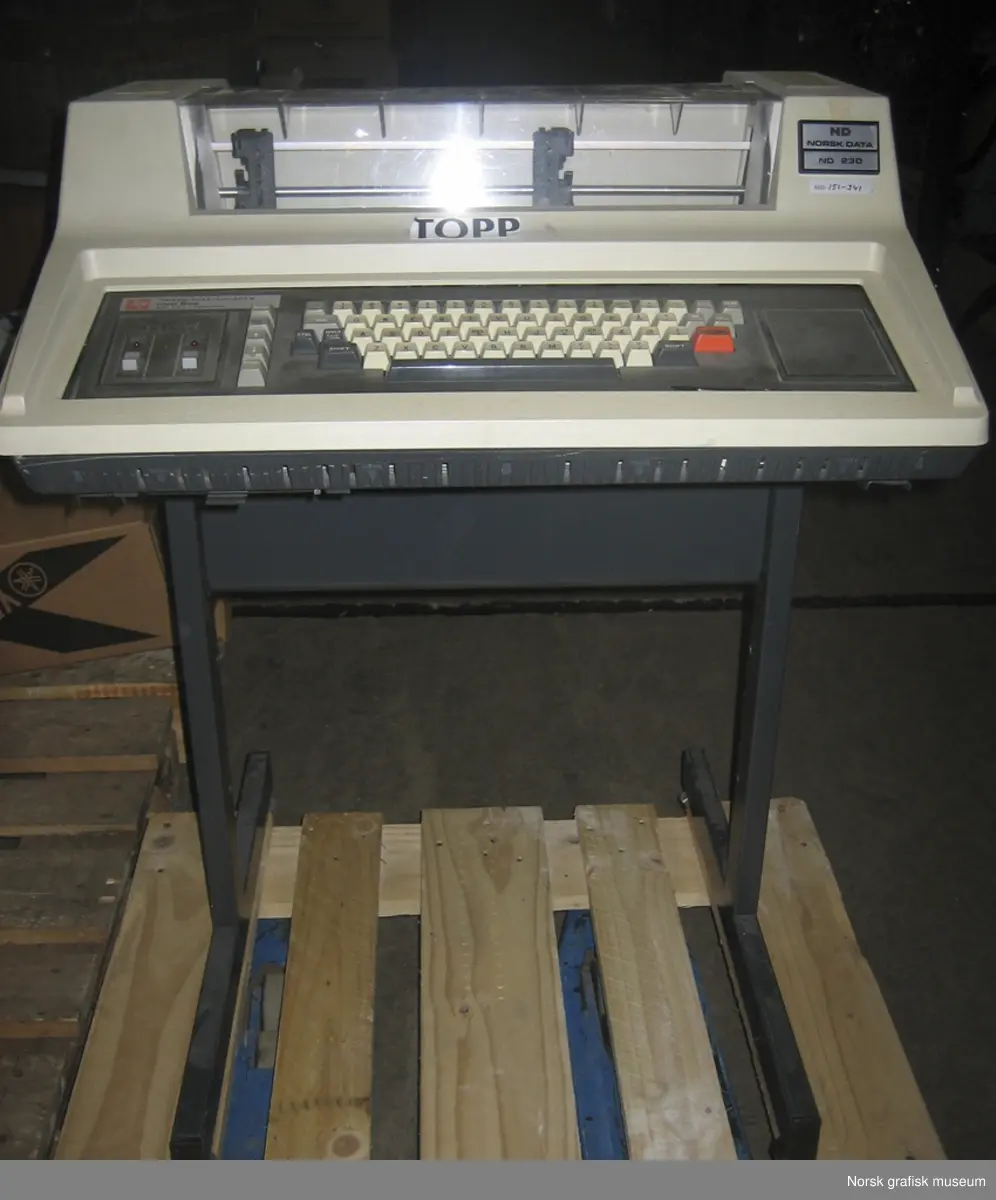 Texas Instruments TI-820 KSR Terminal. Matriseskriver med "traktor-fremtrekk" av papiret. Del av Texas Instruments' Omni 800 "printer-familie". Skriveren har tydeligvis vært en fast del av Norsk Datas datakomponenter, da den har fått NDs nummer 230 (og 151-341) i tillegg til produsentens serienummer.